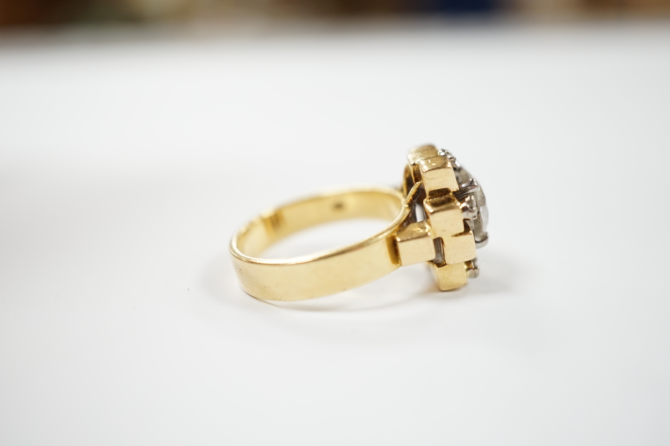 A 1970's 18ct gold and single stone diamond set ring, with five stone diamond mounted setting, size L, gross weight 10.1 grams, the central stone weighing approximately 1.40ct.